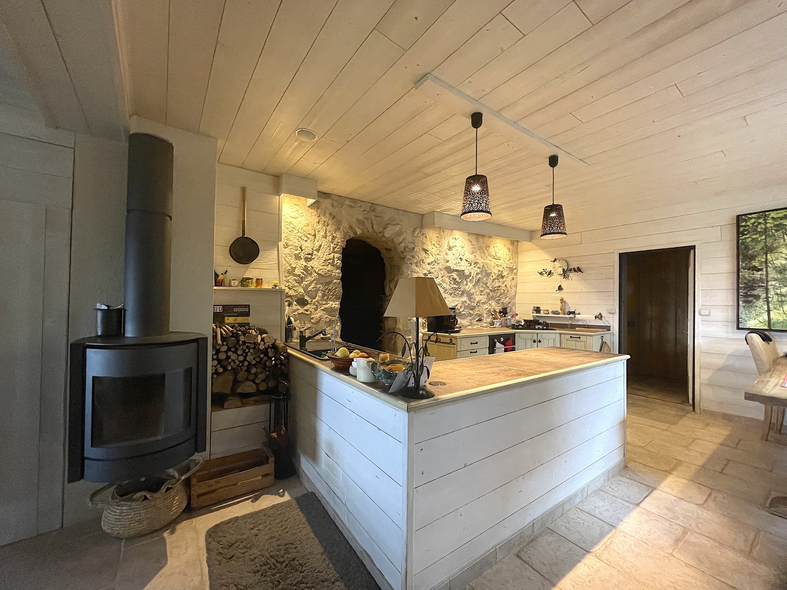 Rustikale Wohnküche mit Kamin und Kochinsel