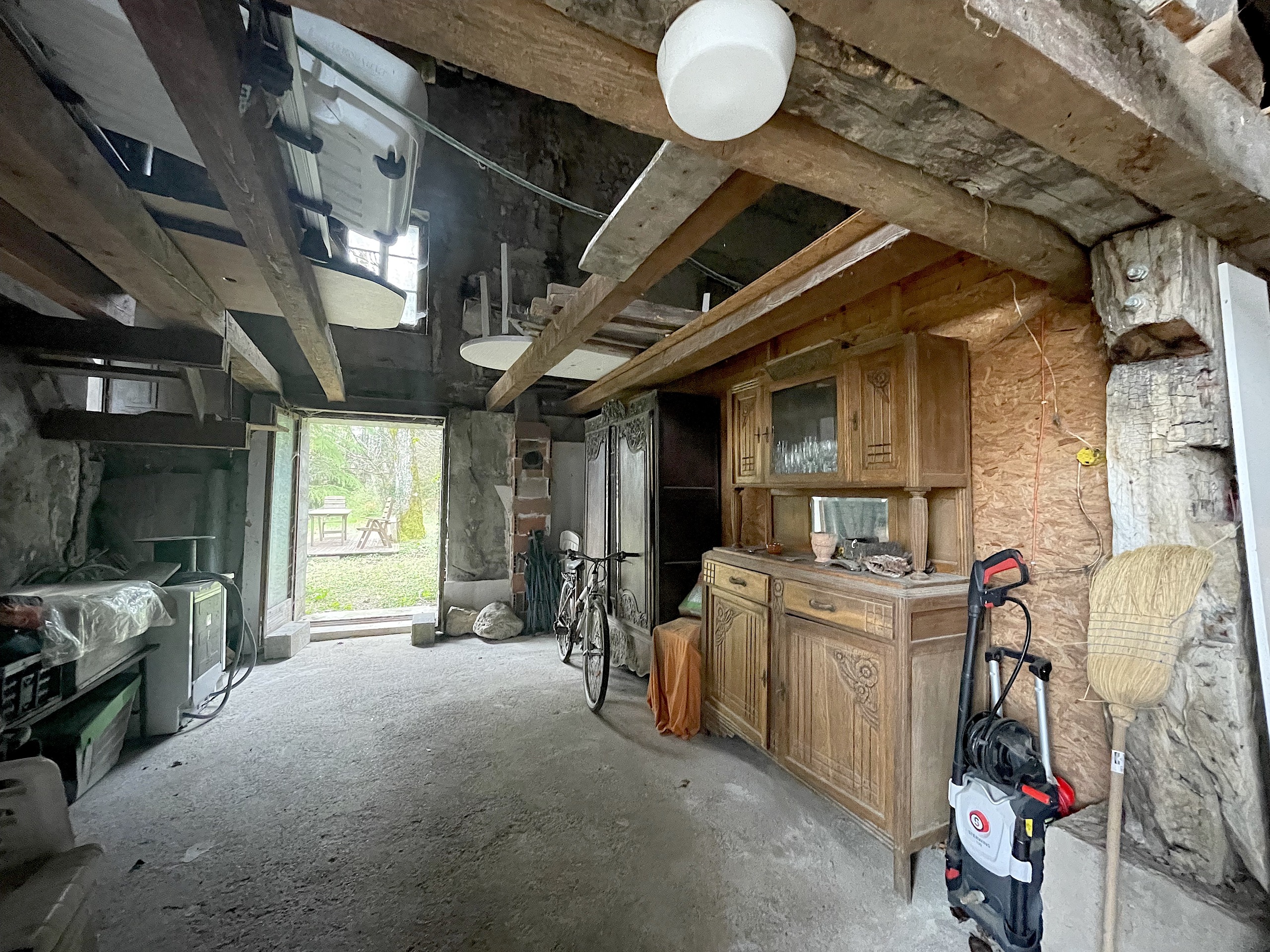 Rustikaler Innenraum mit sichtbaren Holzbalken und offener Lager-/Abstellnutzung