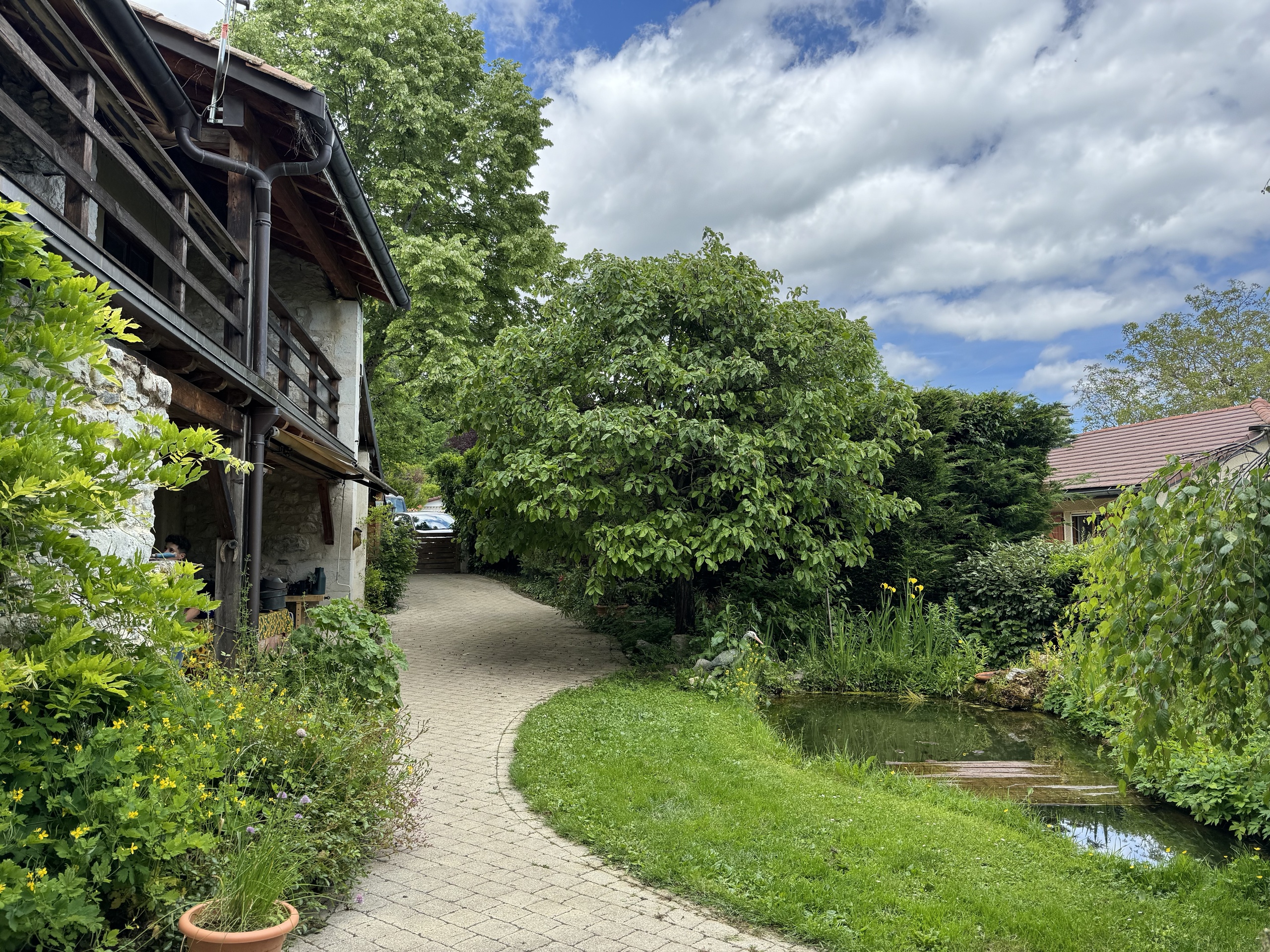 Ländlicher Garten mit Teich und Holzhaus