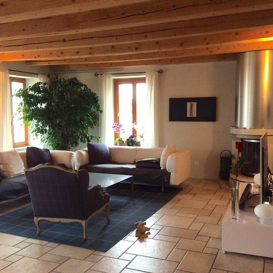 Gemütliches Wohnzimmer mit Holzbalkendecke und Kamin