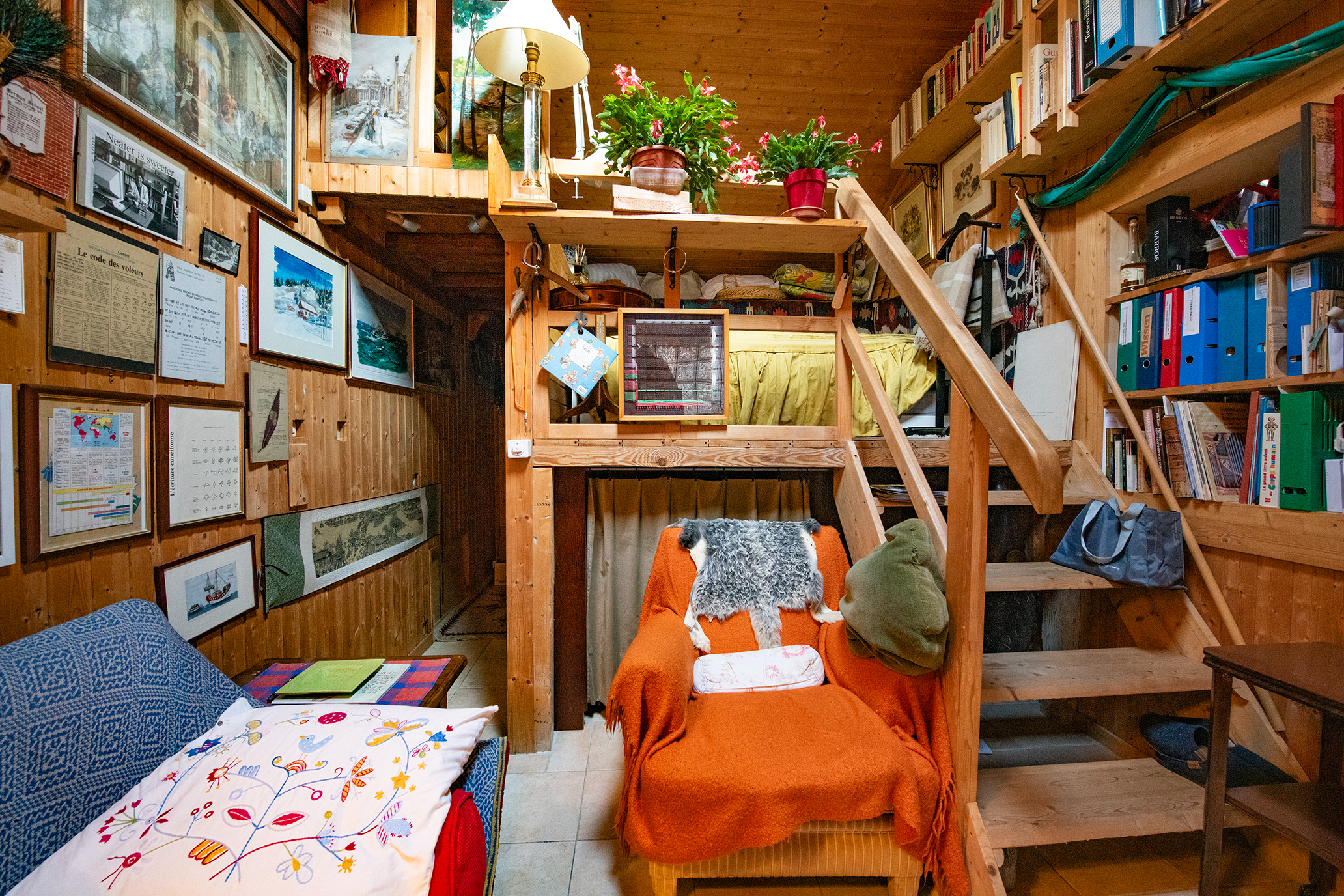 Gemütlicher, holzgetäfelter Wohnbereich mit Galerie und Schlafnische