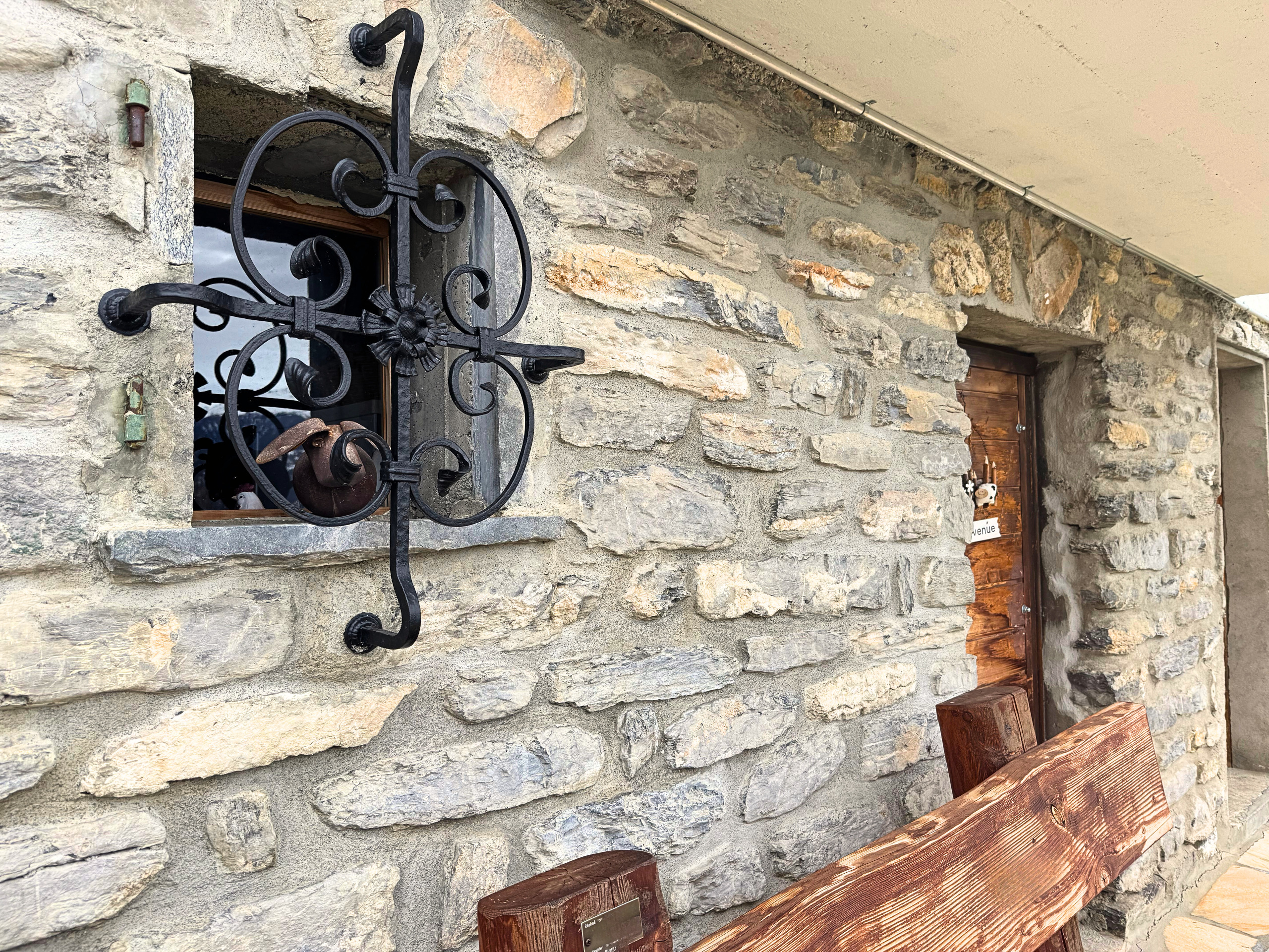 Rustikale Steinfassade mit Eisenfenstergitter