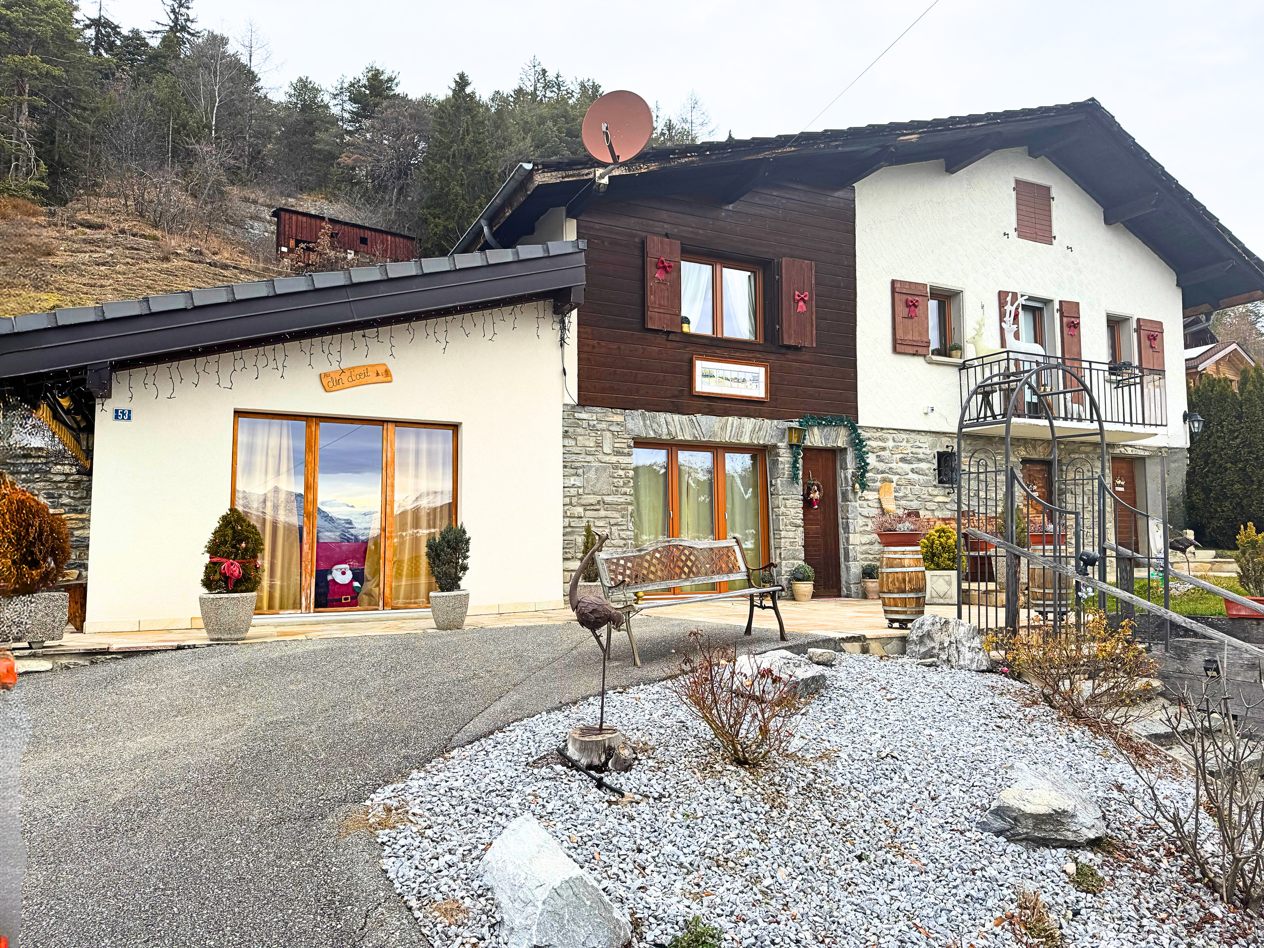 Alpines Einfamilienhaus mit Wintergarten und rustikaler Fassade