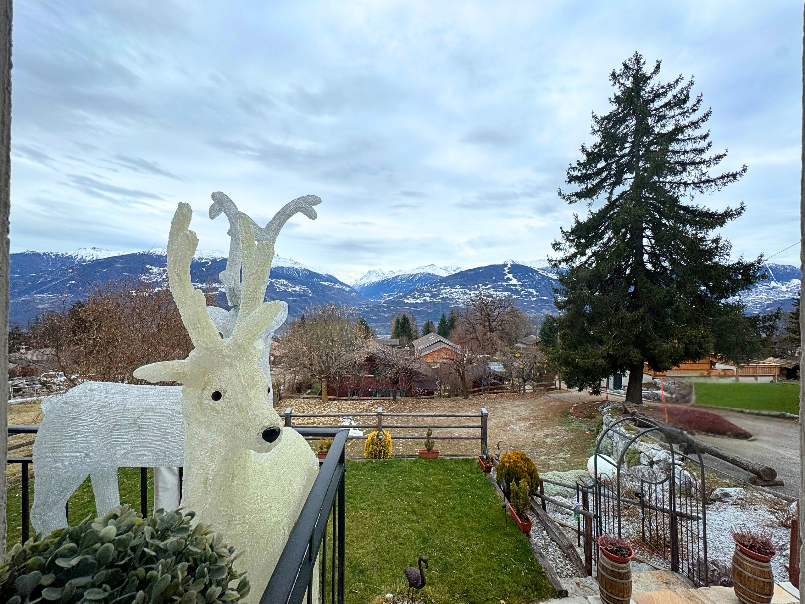 Bergblick von einem Garten mit dekorativen Figuren