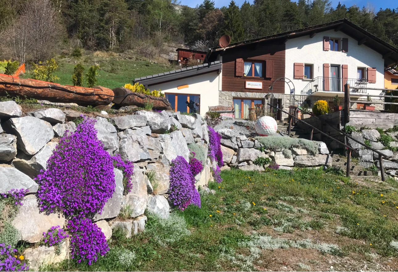 Alpenhaus mit Garten und Steinmauern
