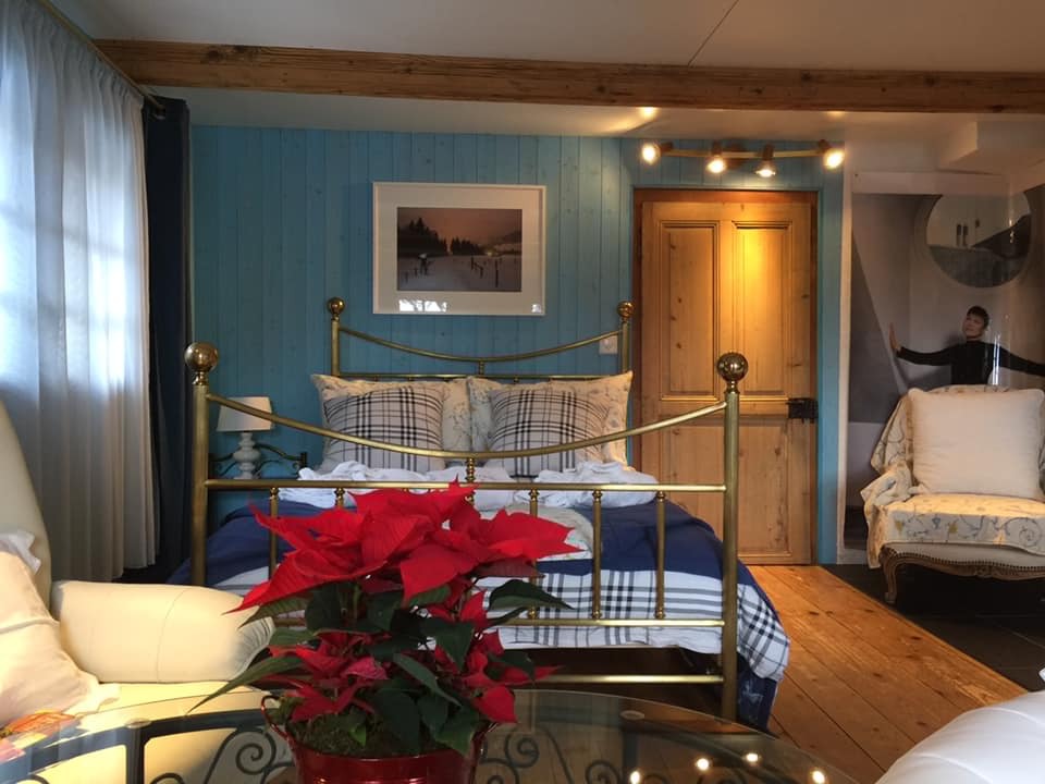 Gemütliches Schlafzimmer mit rustikalen Holzbalken und Messingbett