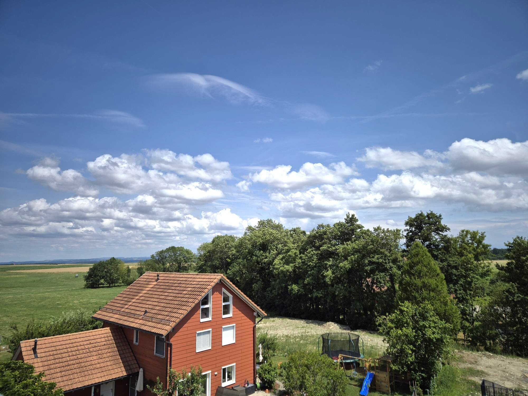 Landschaftsaufnahme mit Wohnhaus und Garten