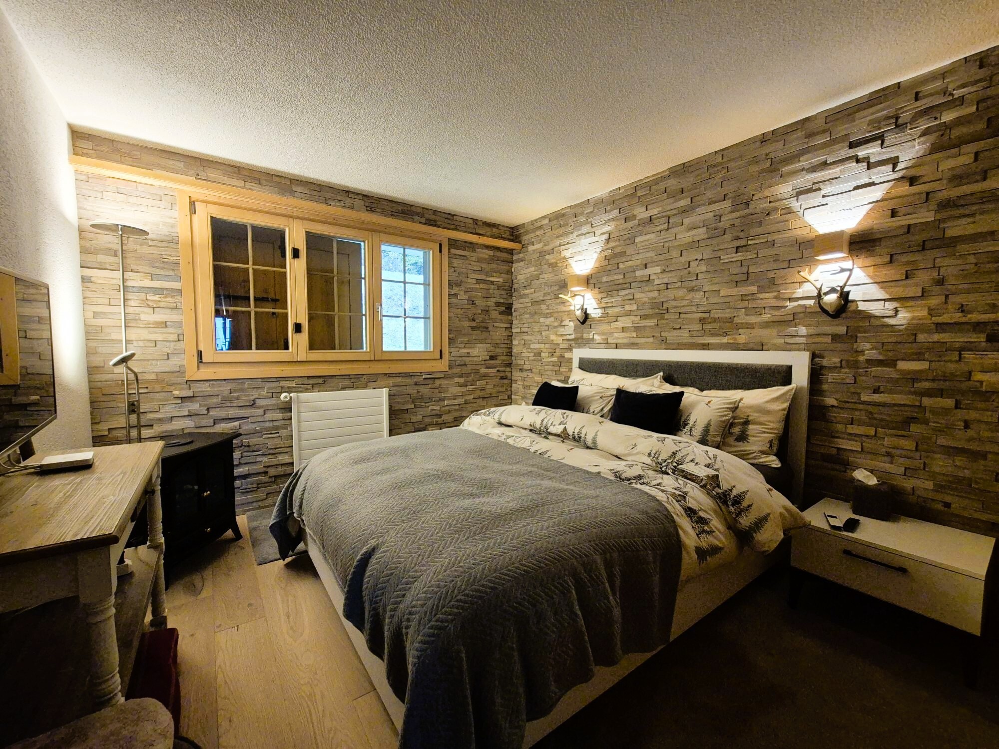 Gemütliches Schlafzimmer mit Steinwand und Holzakzenten