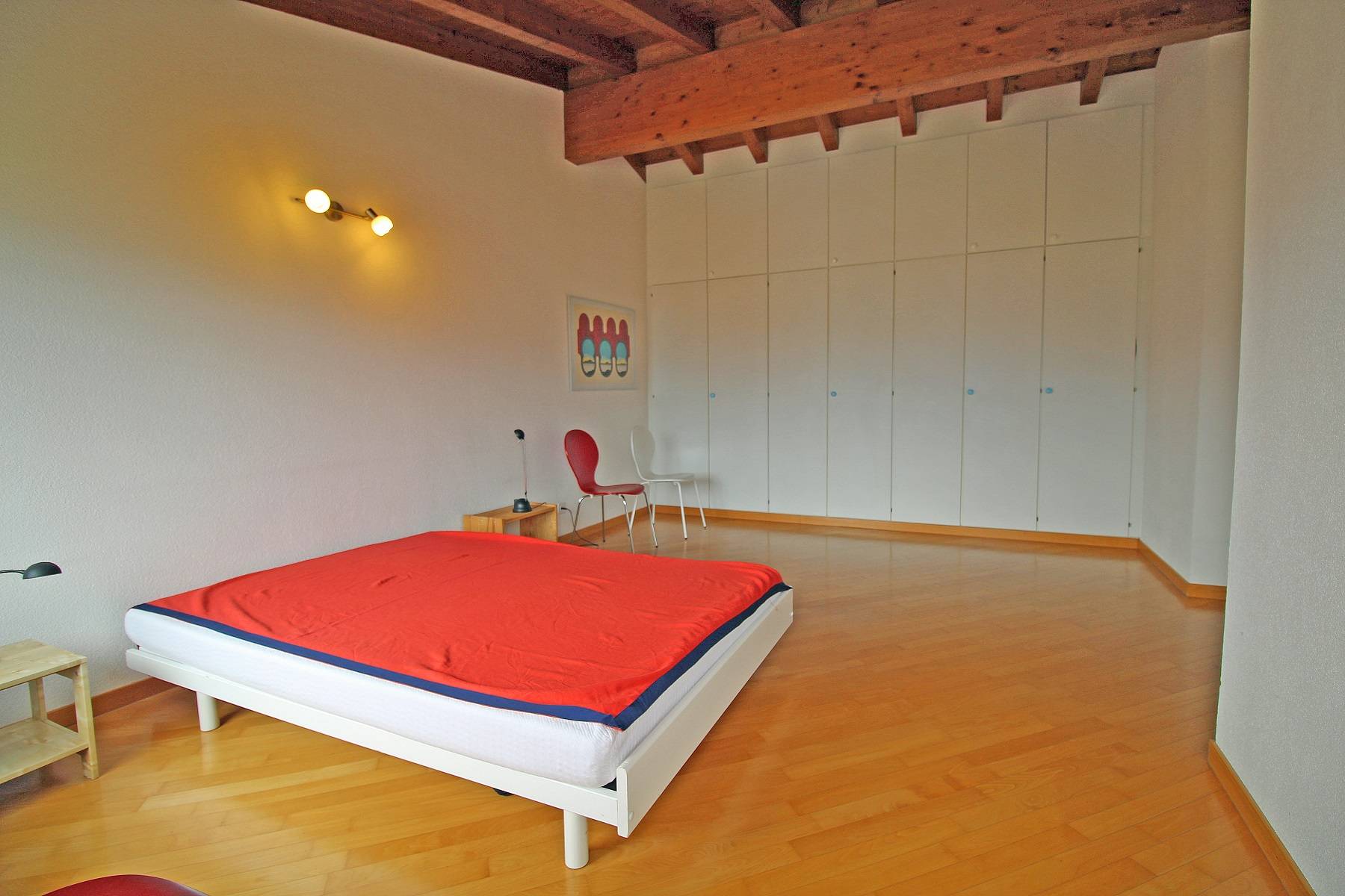 Helles Schlafzimmer mit Holzdecke und Einbauschränken