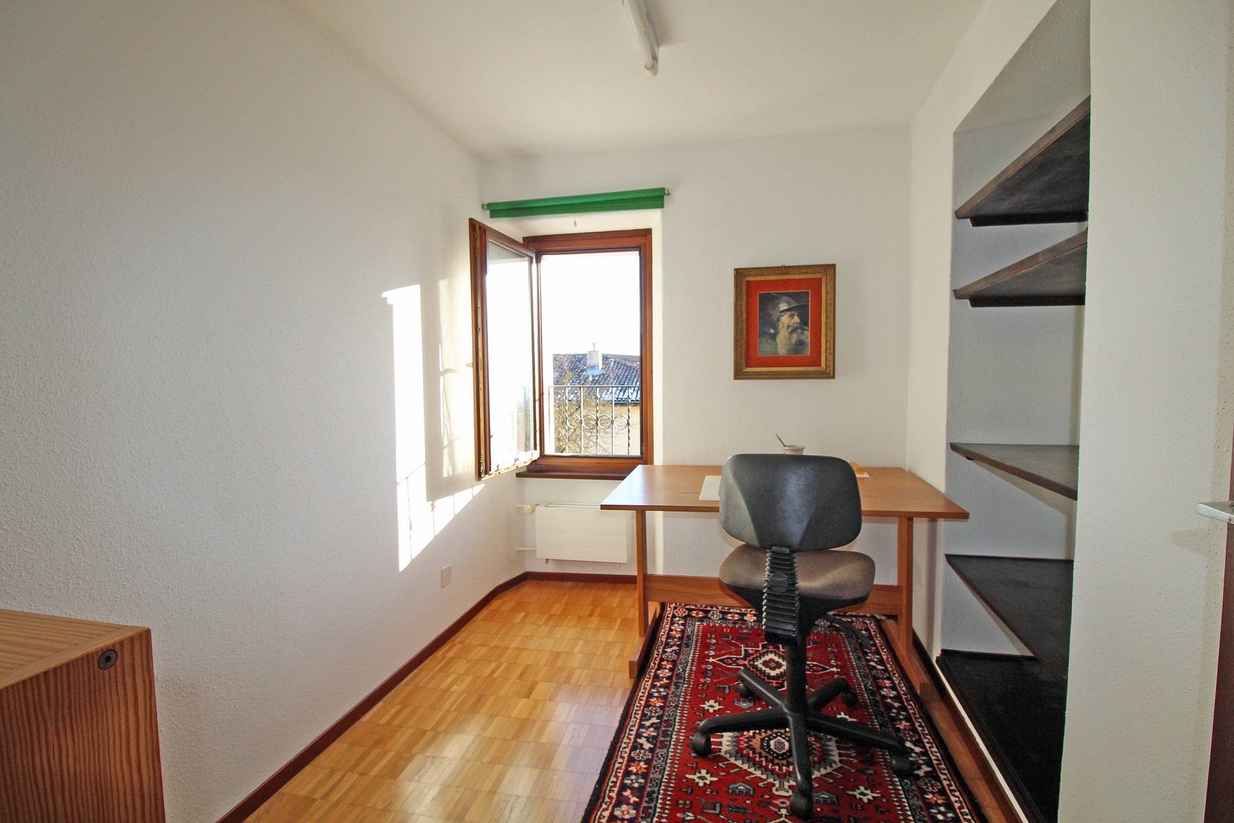 Kleines Arbeitszimmer mit Fenster und Regal