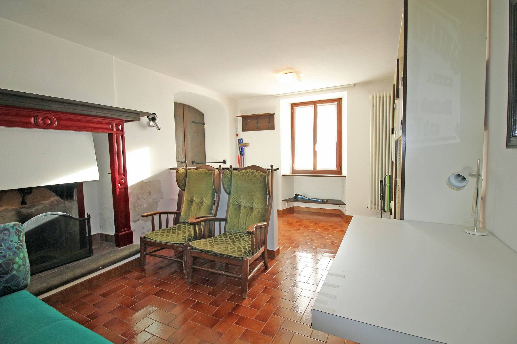 Wohnzimmer mit Kamin und Terrakottaboden