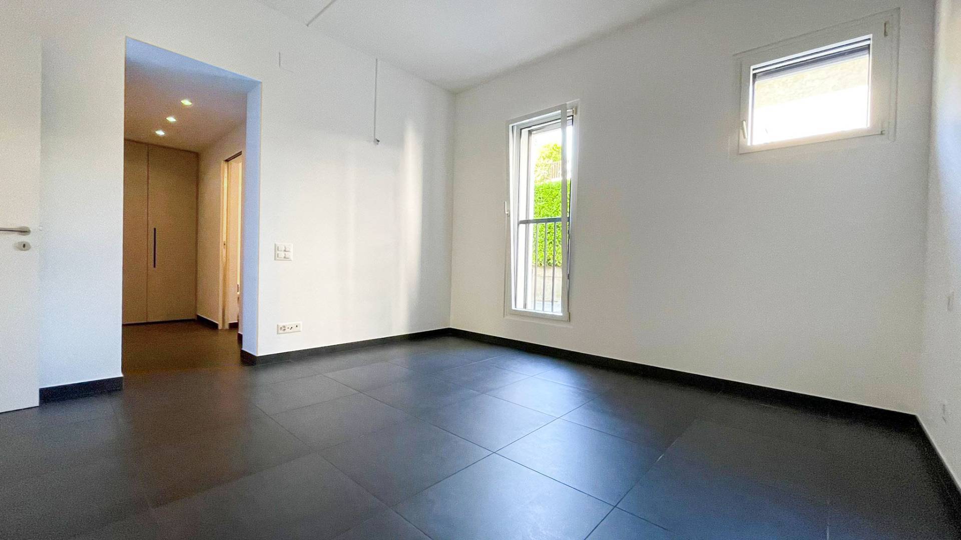 Leerer moderner Raum mit dunklem Boden