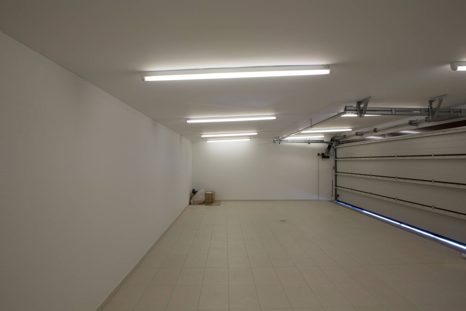 Große, leergeräumte Garage mit Fliesenboden