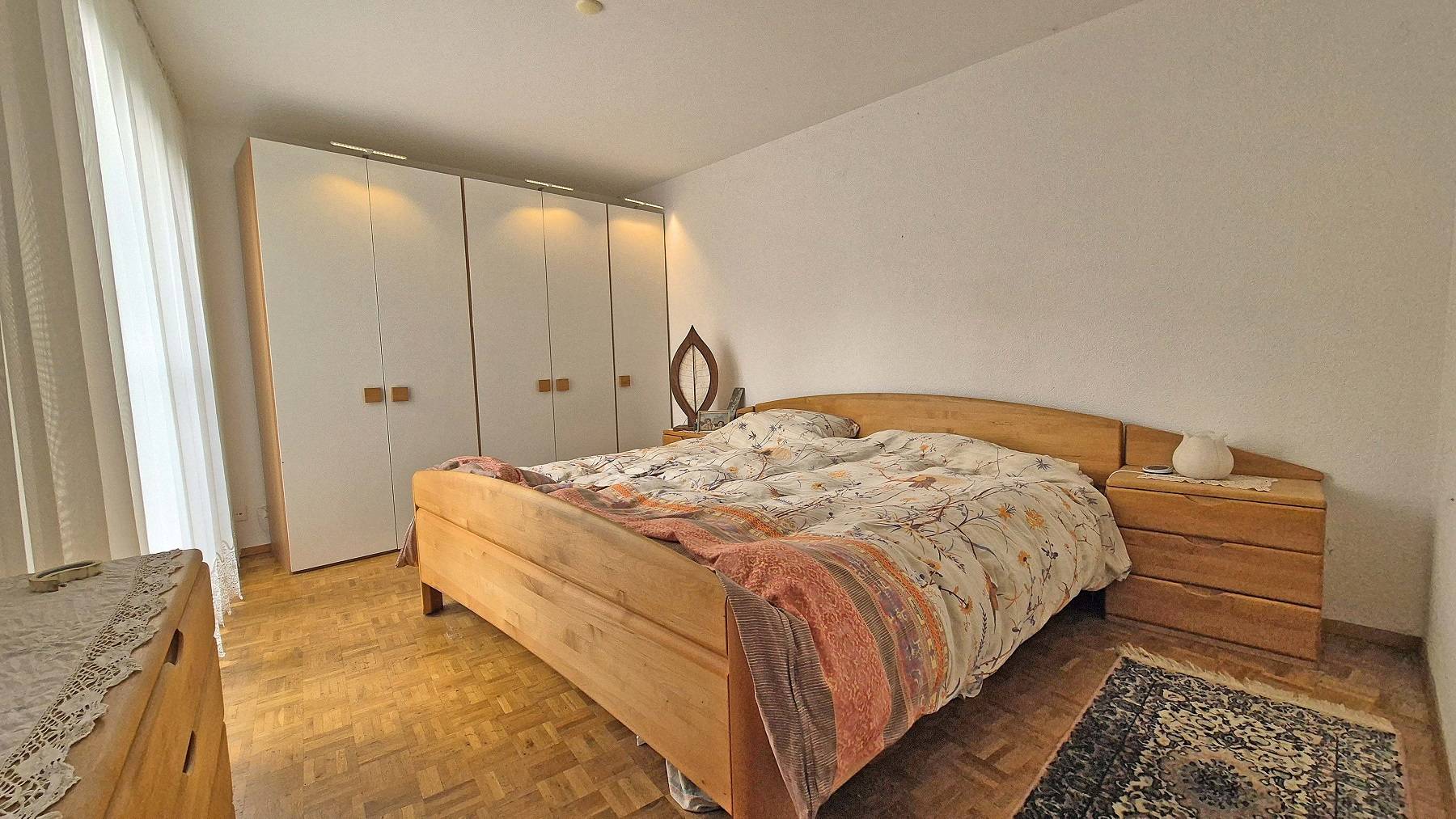 Schlafzimmer mit Holzbett und Einbauschrank