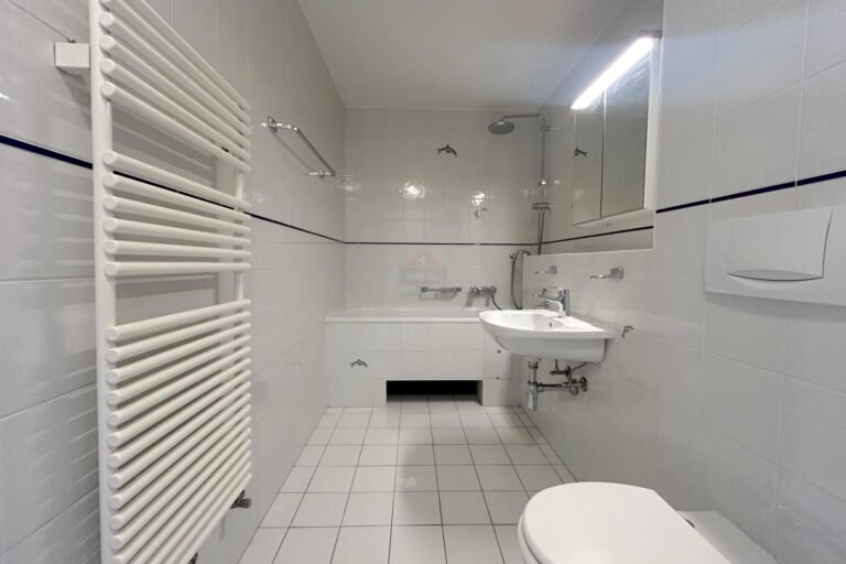 Helles Badezimmer mit Badewanne und bodengleicher Dusche
