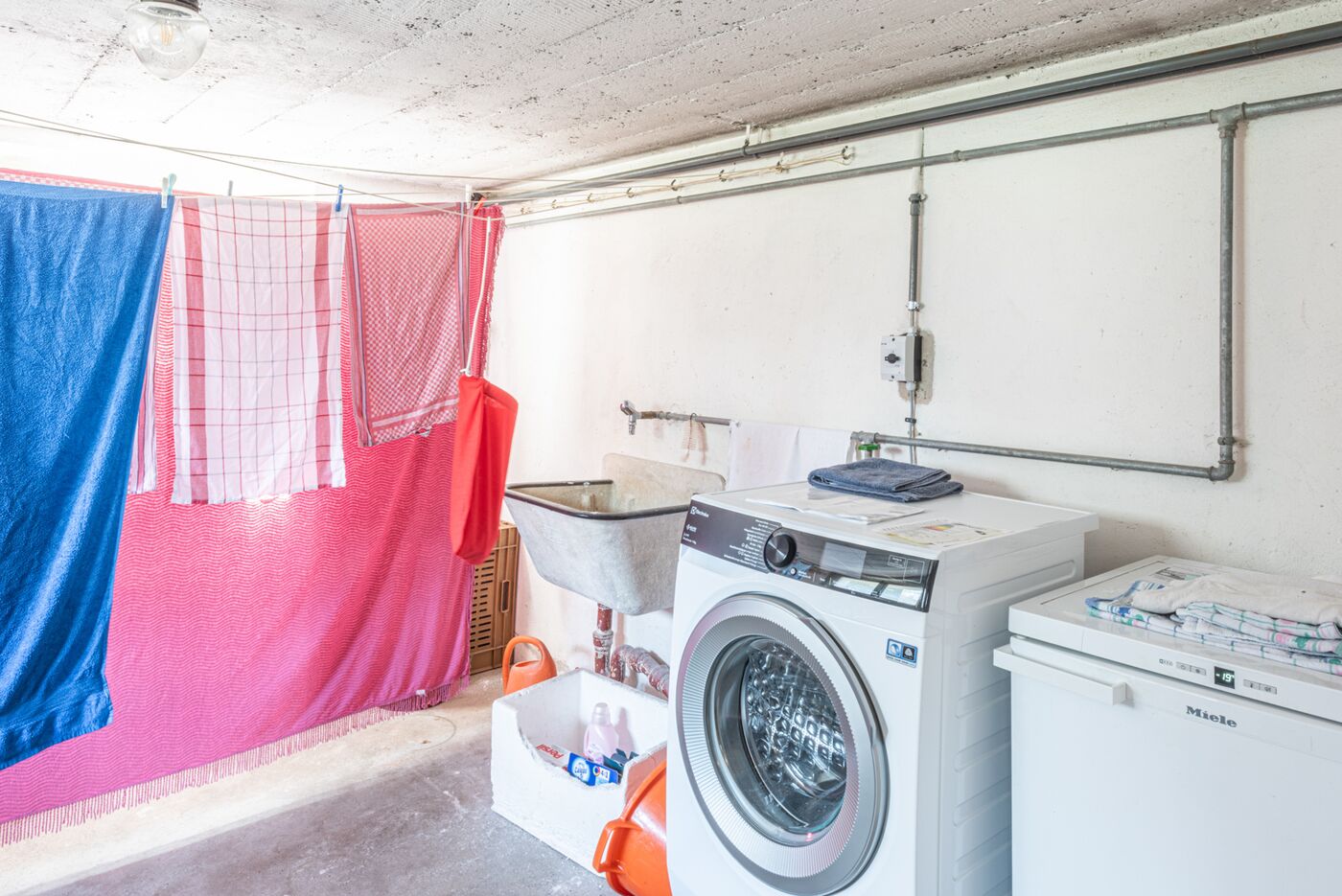 Hauswirtschaftsraum mit Waschmaschine und Wäscheleine
