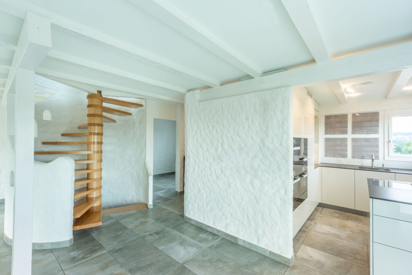 Offener Wohnbereich mit Küche und Wendeltreppe