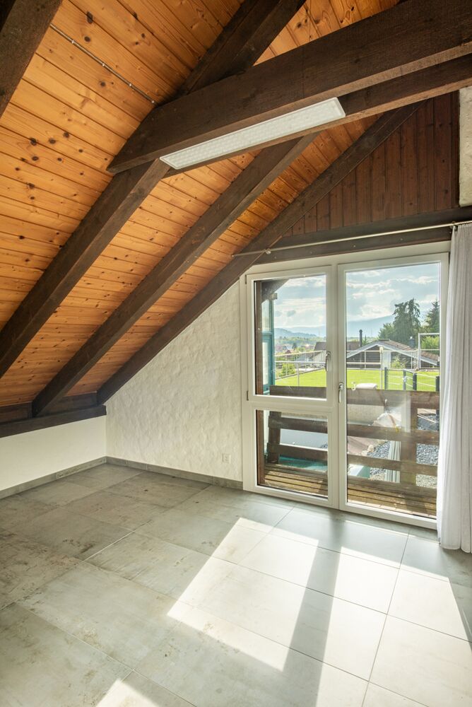 Dachzimmer mit Dachschrägen und Balkonblick