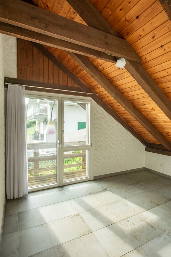 Dachgeschosszimmer mit sichtbaren Holzbalken