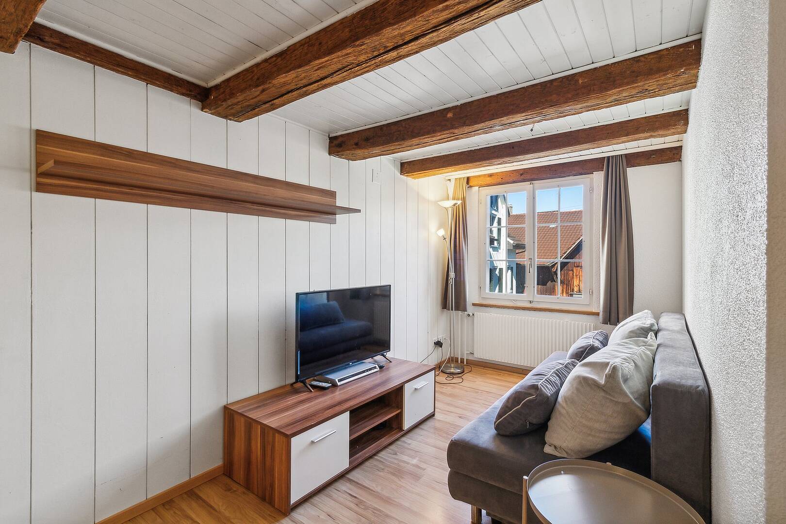 Helles Wohnzimmer mit sichtbaren Holzbalken