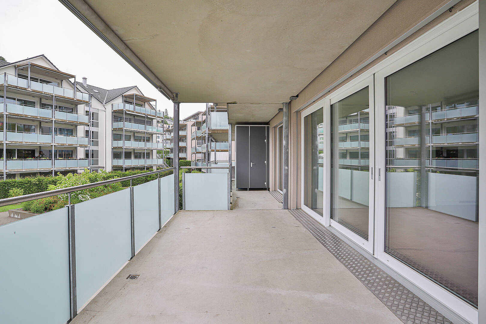 Überdachter Balkon mit Blick auf Wohnanlage