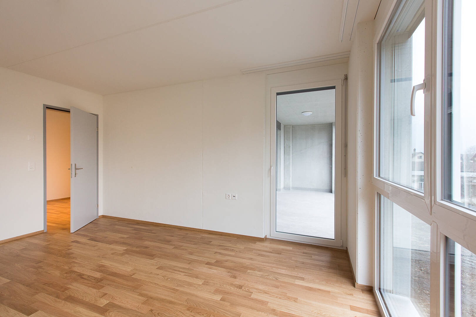 Helles leeres Zimmer mit Holzfußboden