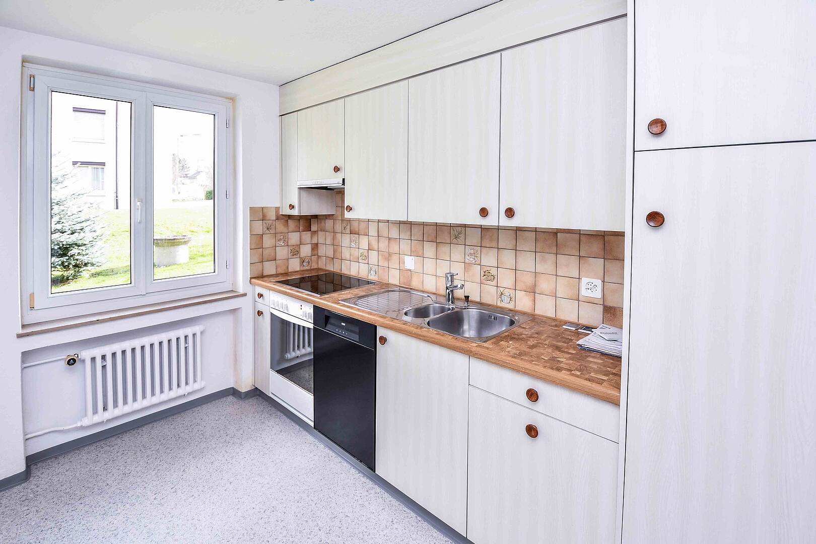 Helle Küche mit Fenster und weißen Fronten