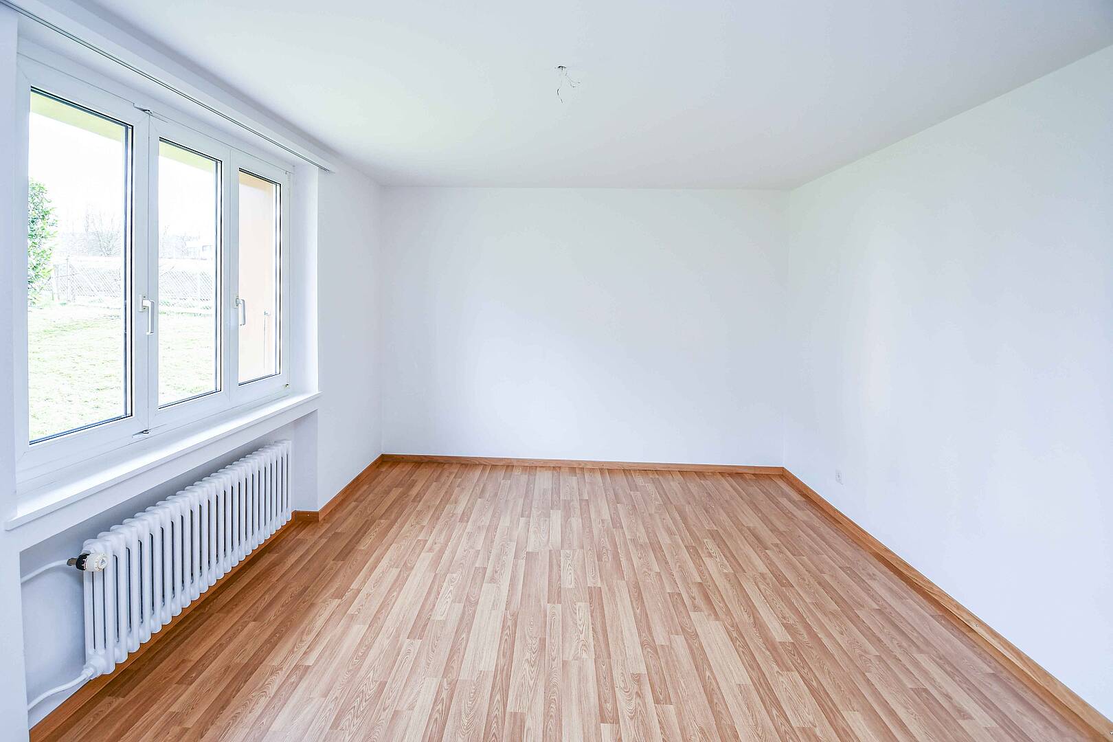 Leerer, heller Raum mit Holzoptik-Boden