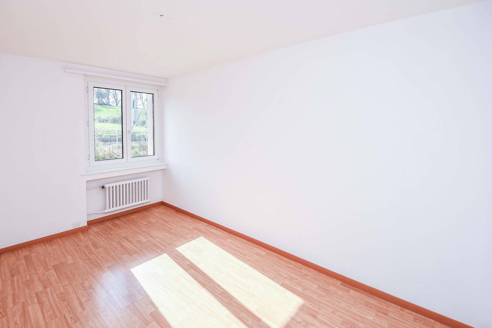 Heller leerer Raum mit Fenster und Heizkörper