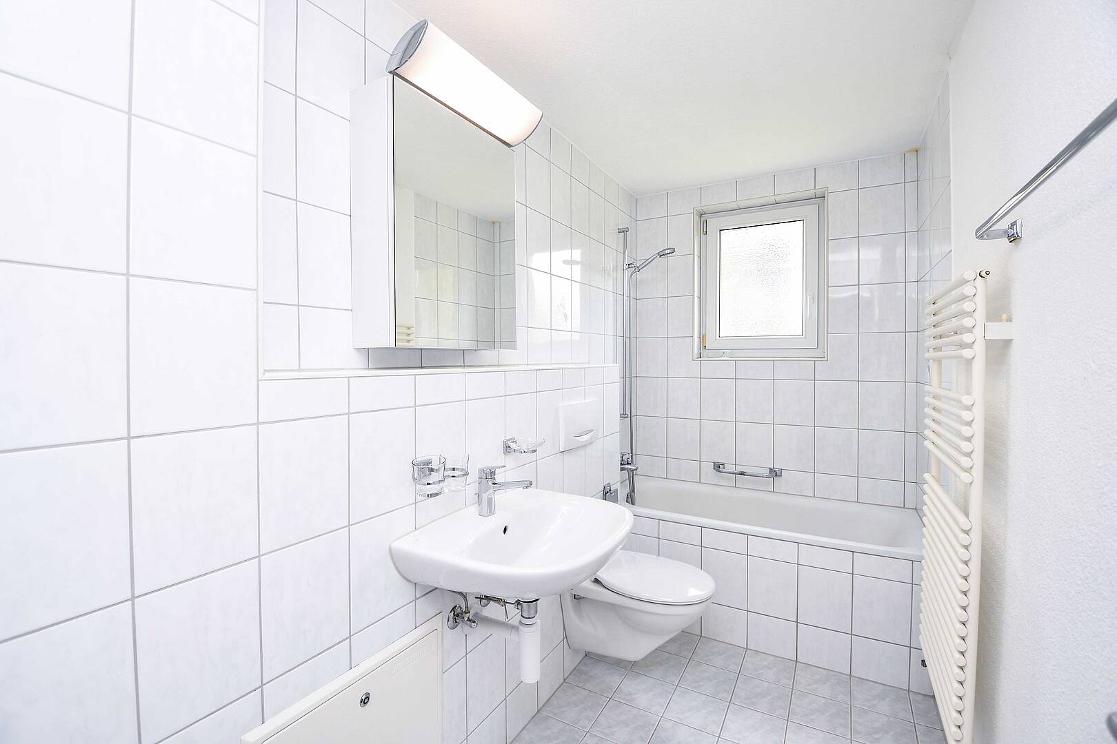 Helles Badezimmer mit Wanne und Waschtisch
