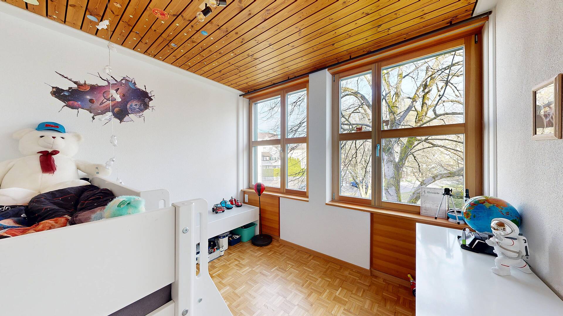 Kinderzimmer mit großen Holzfenstern