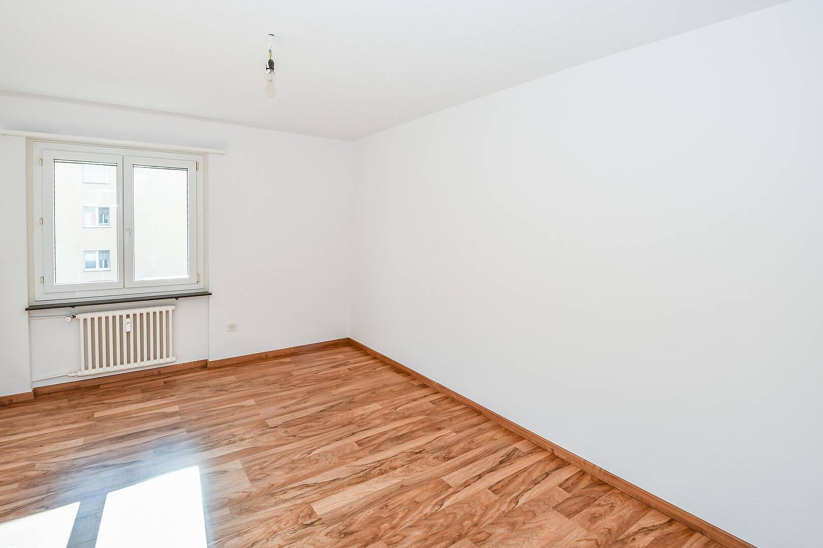 Heller leerer Raum mit Fenster und Heizkörper
