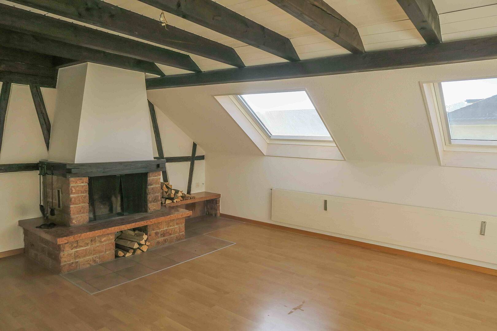 Dachgeschosszimmer mit Kamin und Dachfenstern