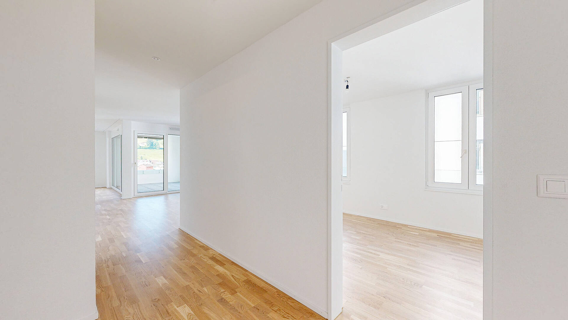 Heller, leerer Wohnbereich mit Flur und Nebenzimmer