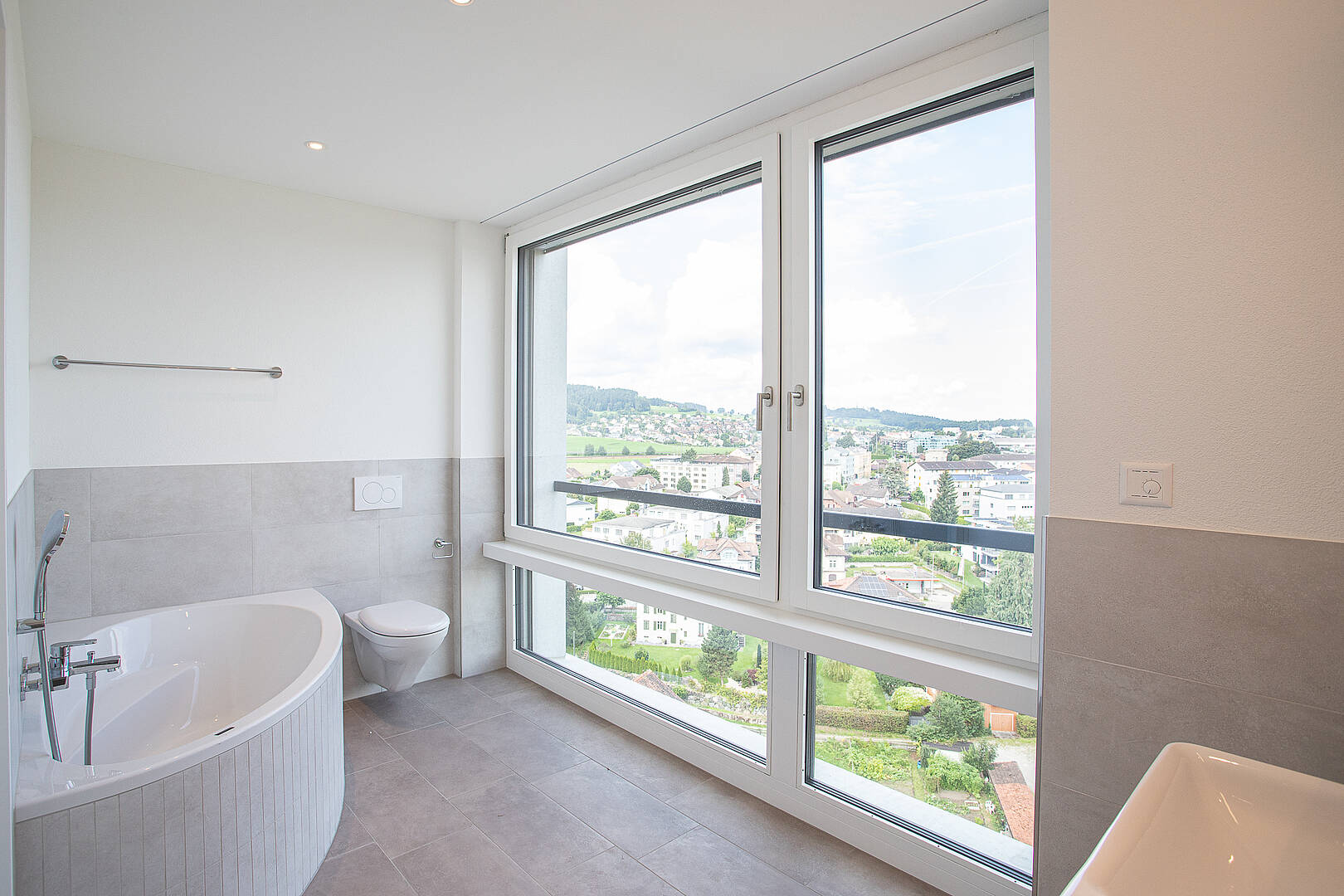 Helles Badezimmer mit Panoramafenster und Badewanne