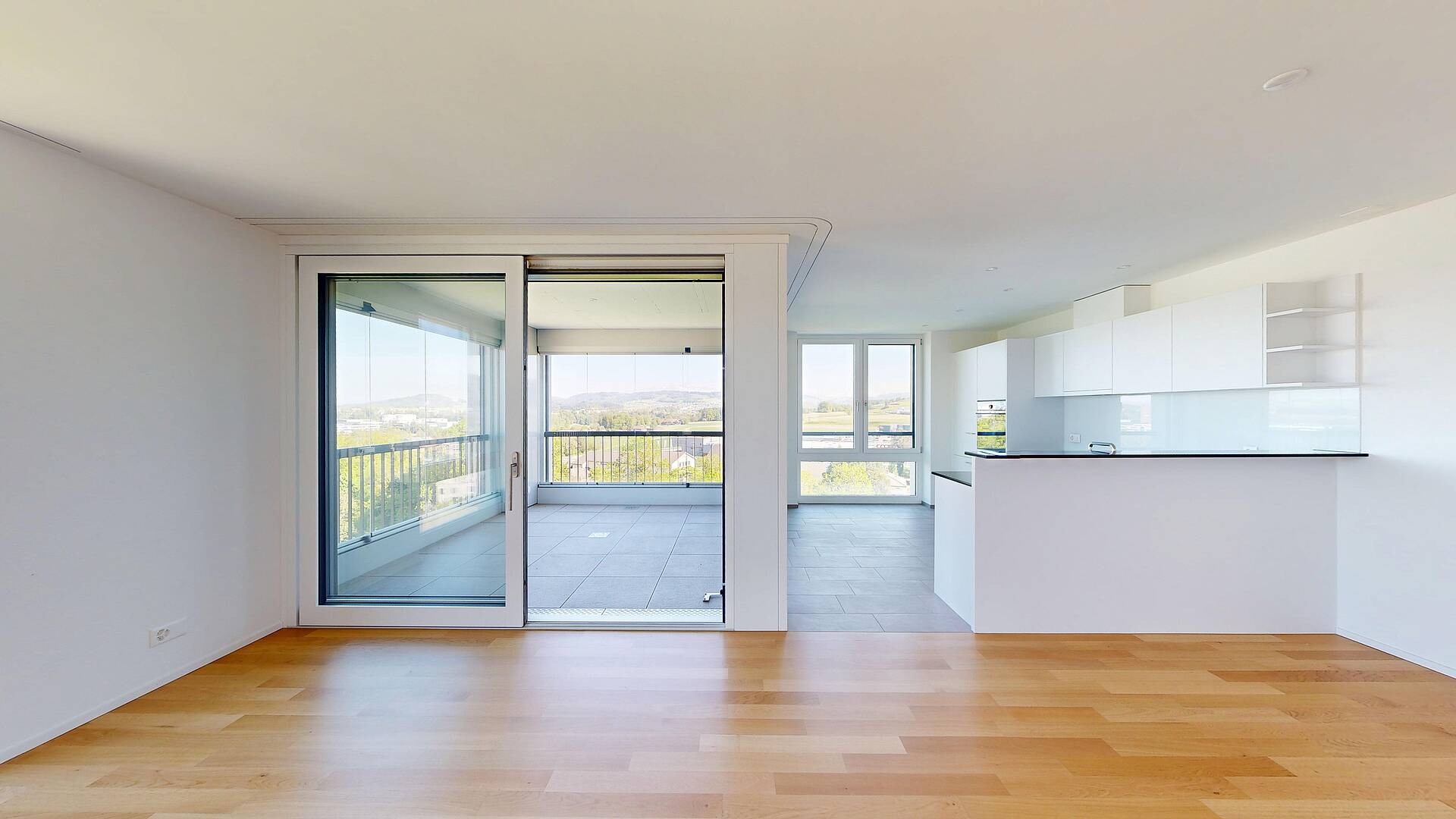 Heller Wohnbereich mit offener Küche und Balkon