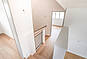 Heller Flur mit Holztreppe