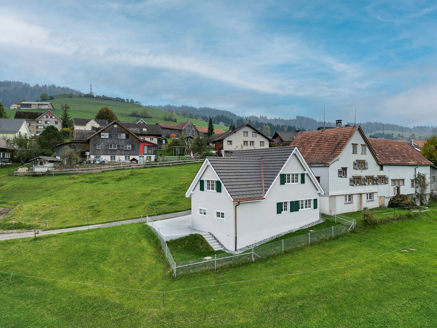Ländliche Häuser mit Blick auf grüne Hügel