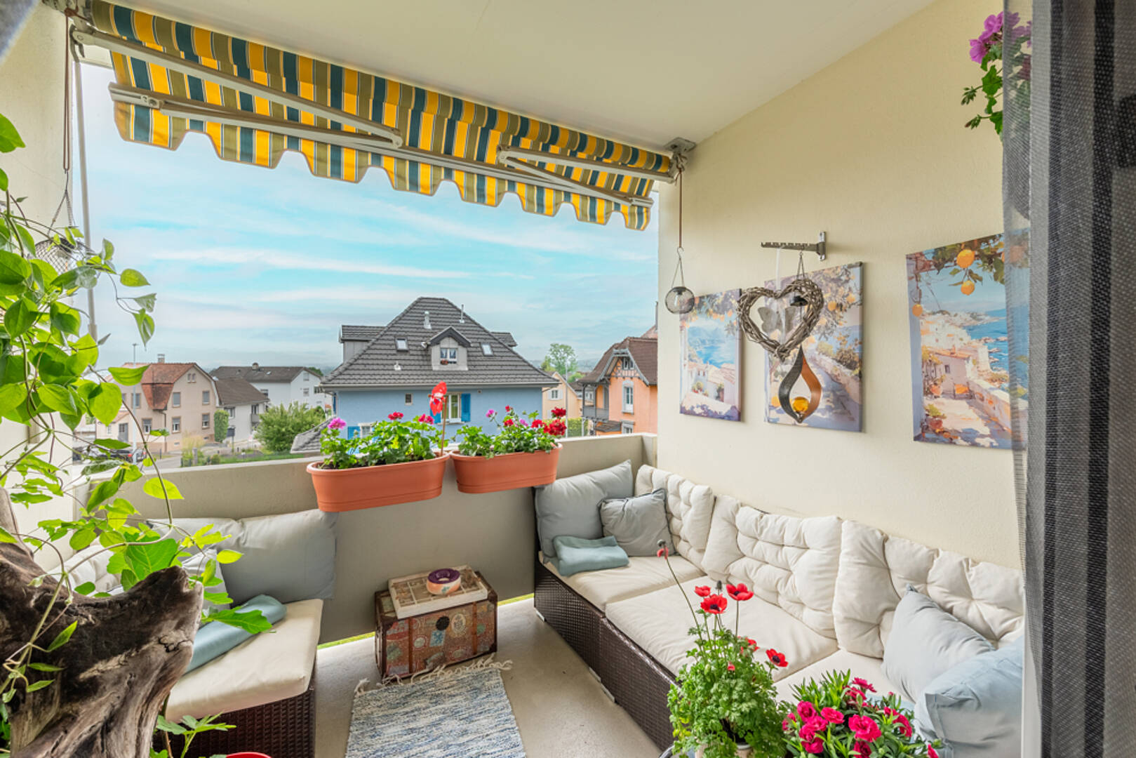 Gemütlicher Balkon mit Sitzgruppe und Blick ins Wohngebiet