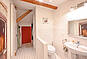 Helles Badezimmer mit heller Holztür und begehbarer Dusche