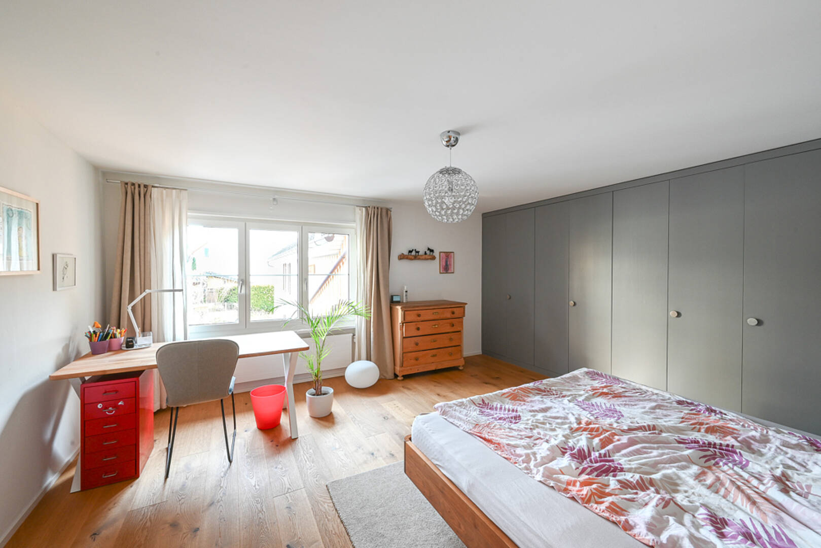 Helles Schlafzimmer mit Schreibtisch und Einbauschränken
