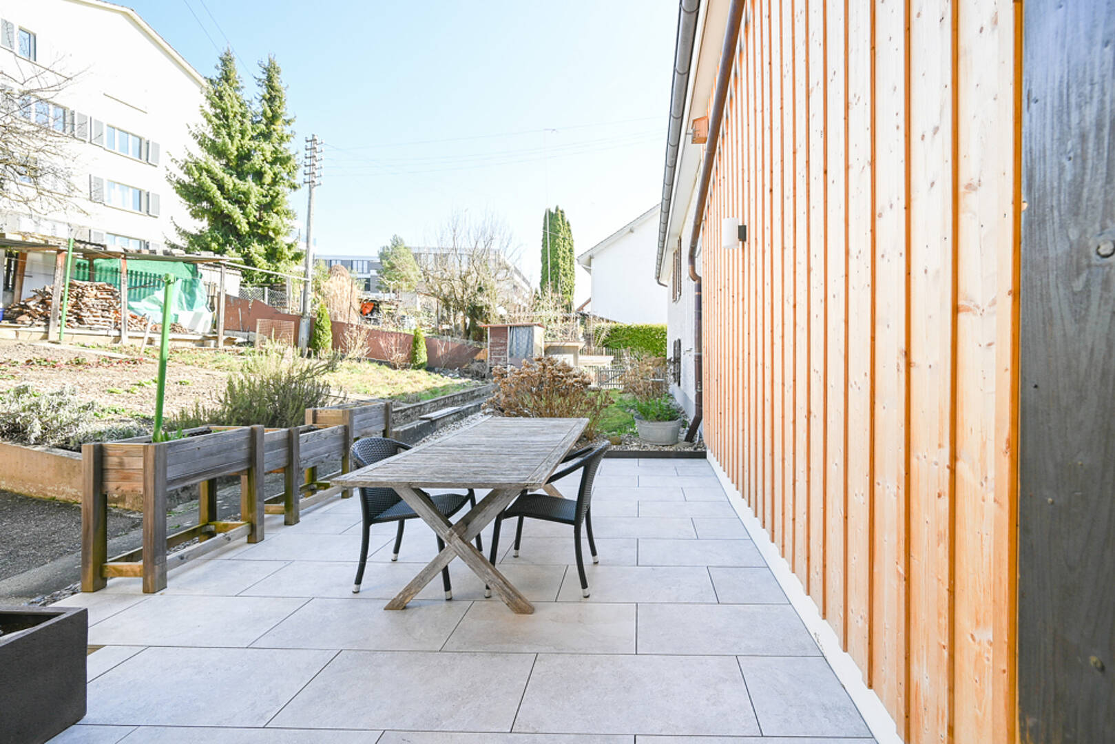 Terrasse mit Holzfassade und Gartenmöbeln