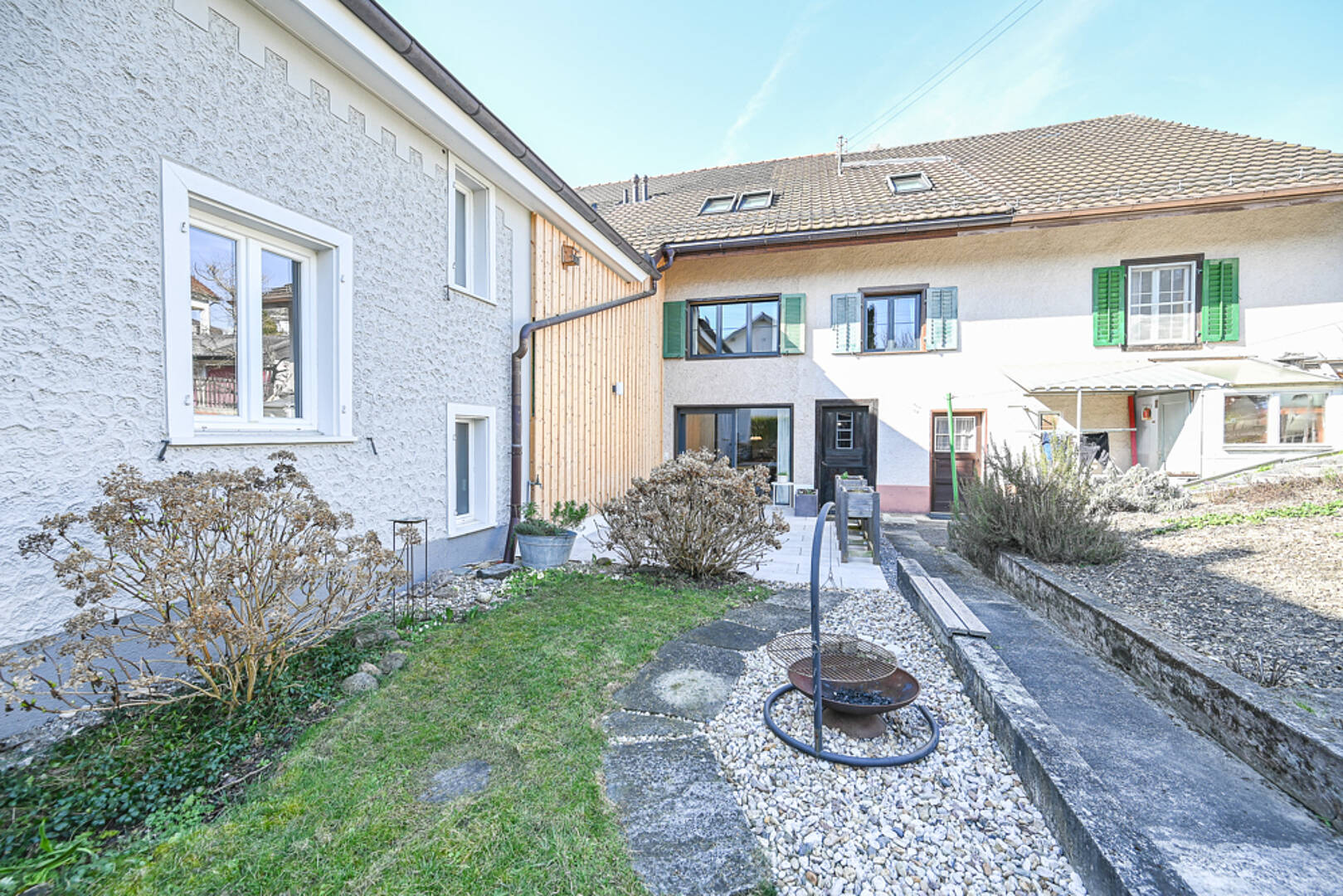 Heller Innenhof mit Garten und Fassadenansicht