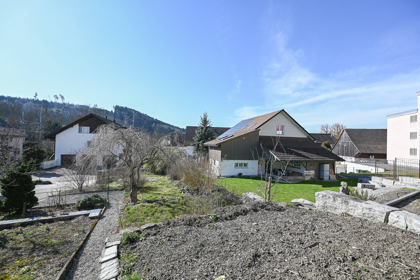 Wohnhäuser mit Garten und Bergkulisse