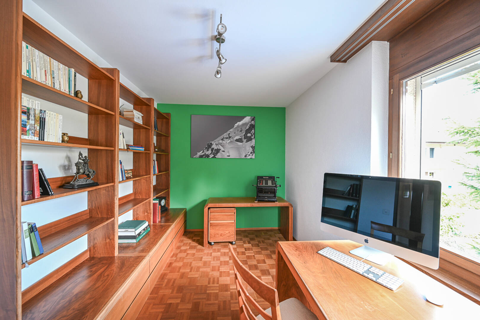 Arbeitszimmer mit Holzregalen und Schreibtisch