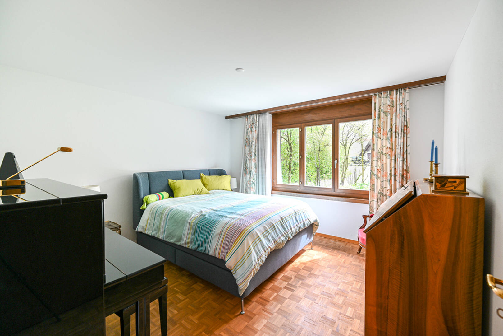 Schlafzimmer mit Holzfenster und Parkettboden