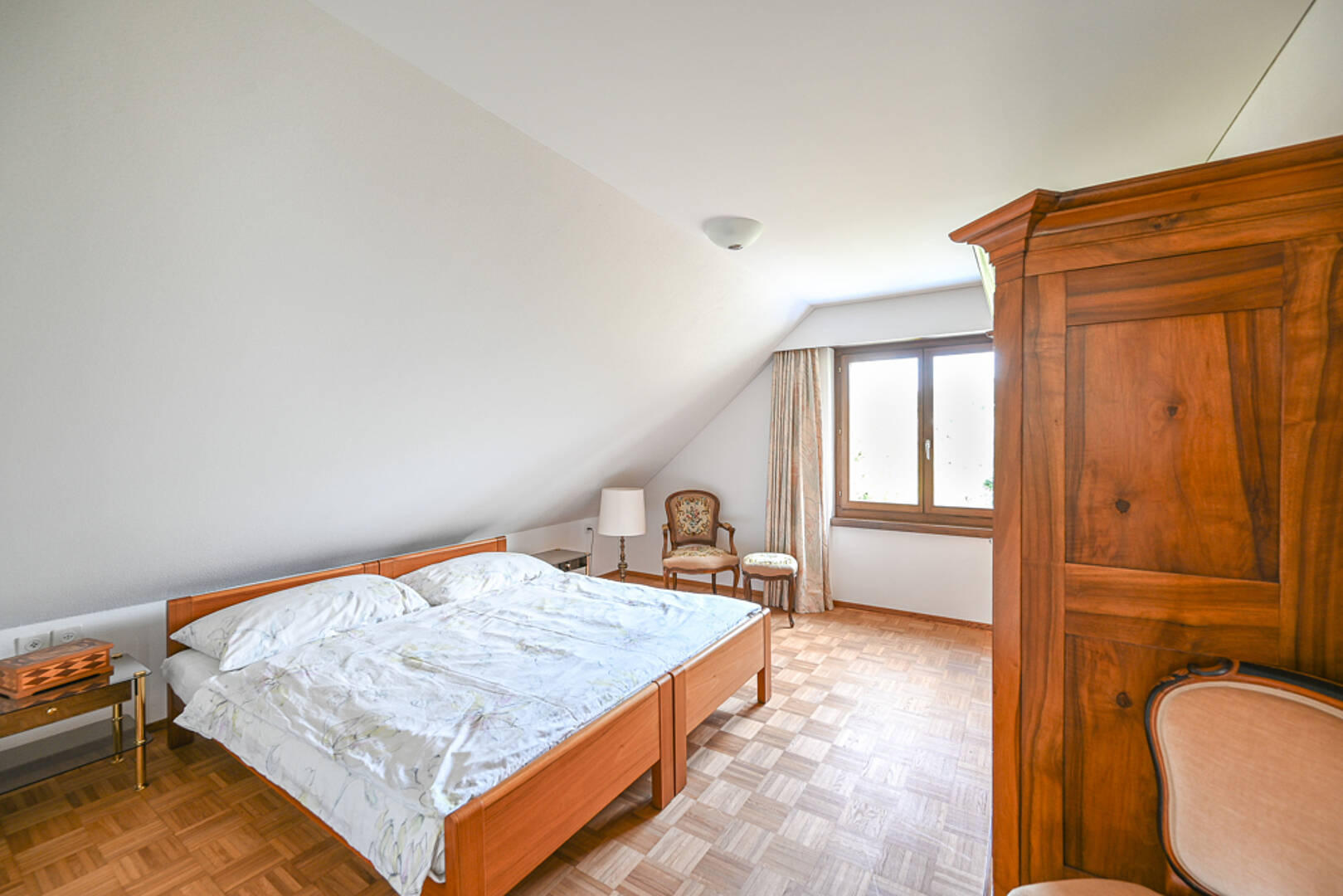 Dachgeschoss-Schlafzimmer mit Holzmöbeln