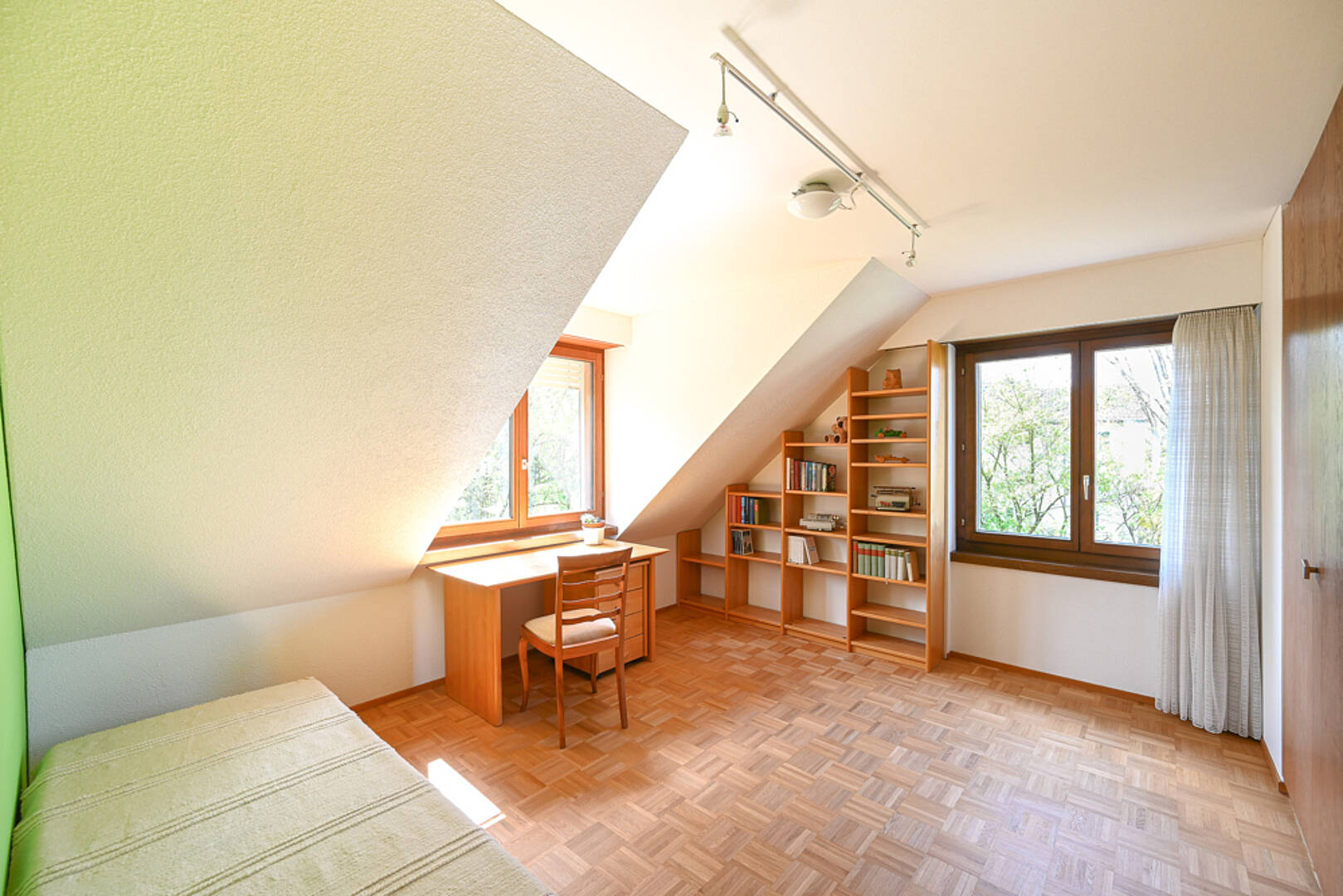 Helles Dachzimmer mit Arbeitsbereich und Bett