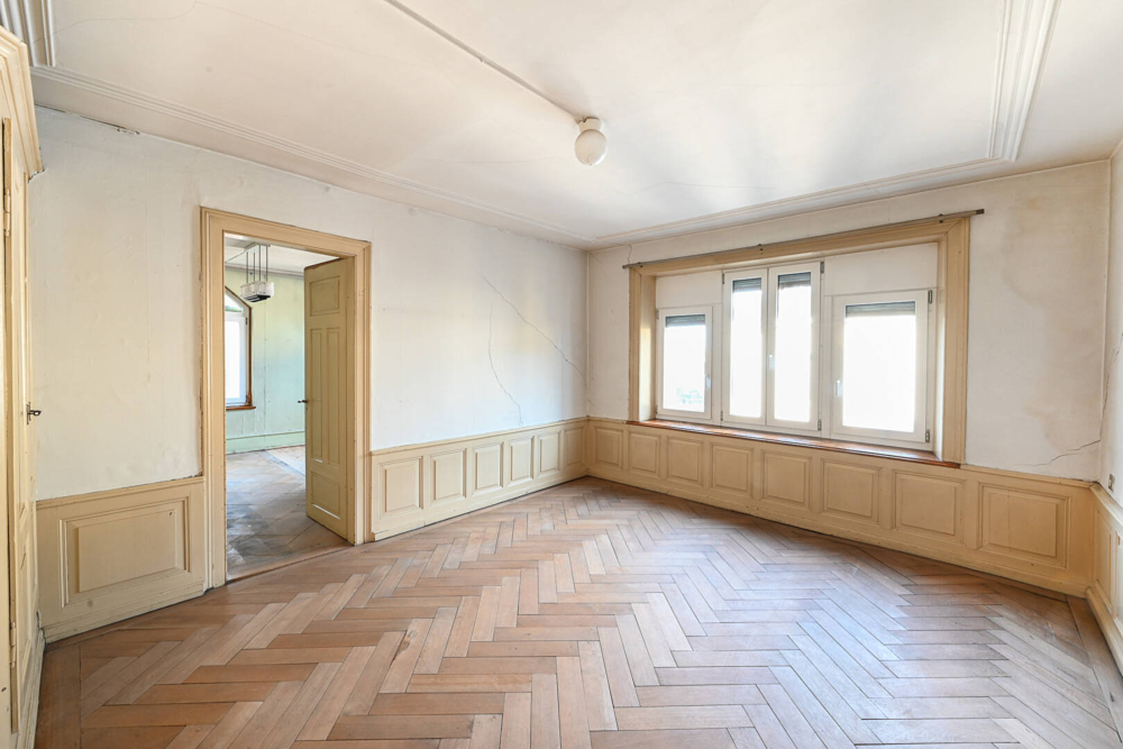 Heller leerer Altbau-Raum mit Parkett und Stuckdecke