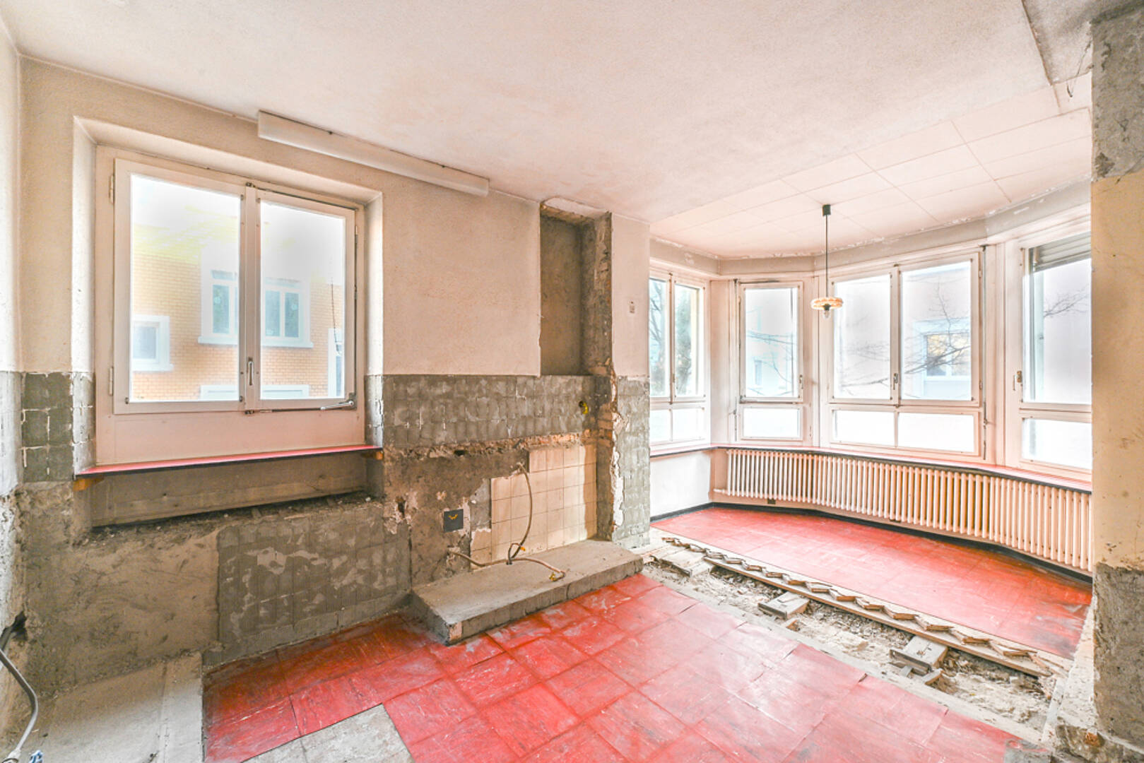 Renovierungsbedürftiger Wohnraum mit großen Fenstern